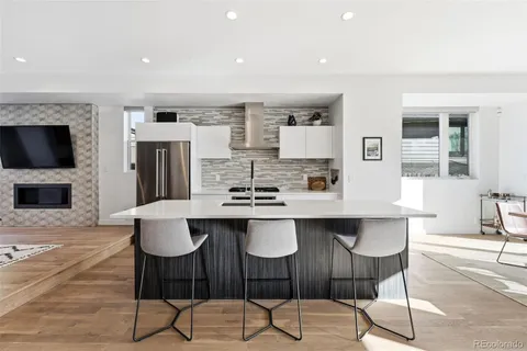 a kitchen with stainless steel appliances a table and chairs in it