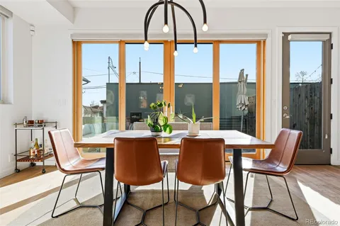 a dining room with furniture a chandelier and wooden floor