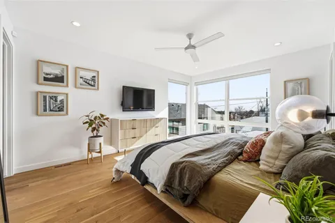 a bedroom with a bed and a flat tv screen on the dresser