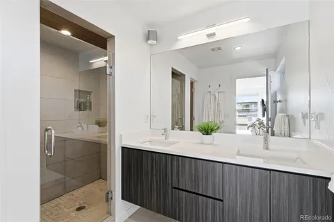 a bathroom with a double vanity sink mirror and shower