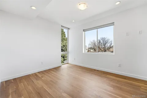 an empty room with wooden floor and window