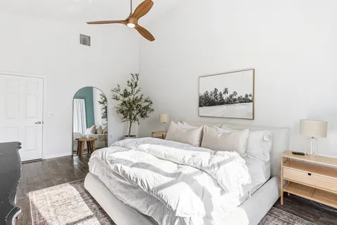 a bedroom with a large bed and a chandelier