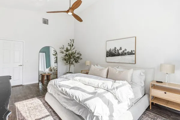 a bedroom with a large bed and a chandelier