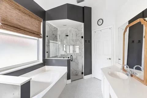 a bathroom with a tub sink and mirror