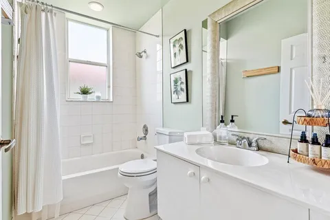 a bathroom with a granite countertop sink a toilet a shower and a mirror