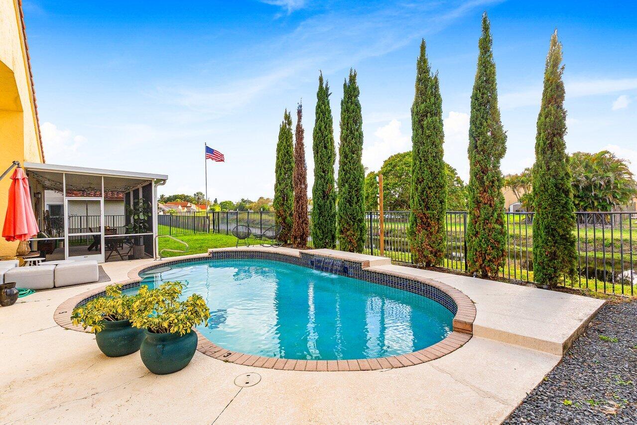 9507 Lake Serena Drive Boca Raton, FL 33496 - Photo 2 of 26 a view of a swimming pool with a lounge chair