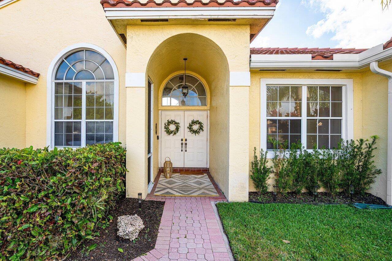 9507 Lake Serena Drive Boca Raton, FL 33496 - Photo 3 of 26 a front view of a house with garden