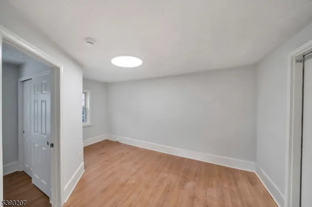 a view of a room with wooden floor and white walls
