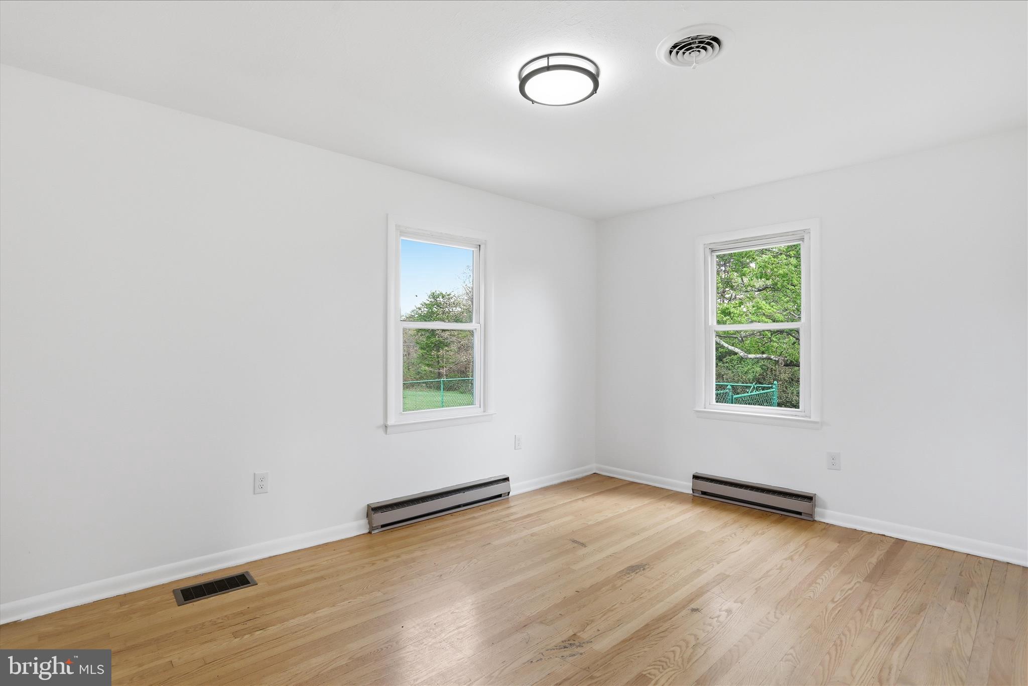 55 Highland Ridge Road Berkeley Springs, WV 25411 - Photo 15 of 44 an empty room with wooden floor and windows