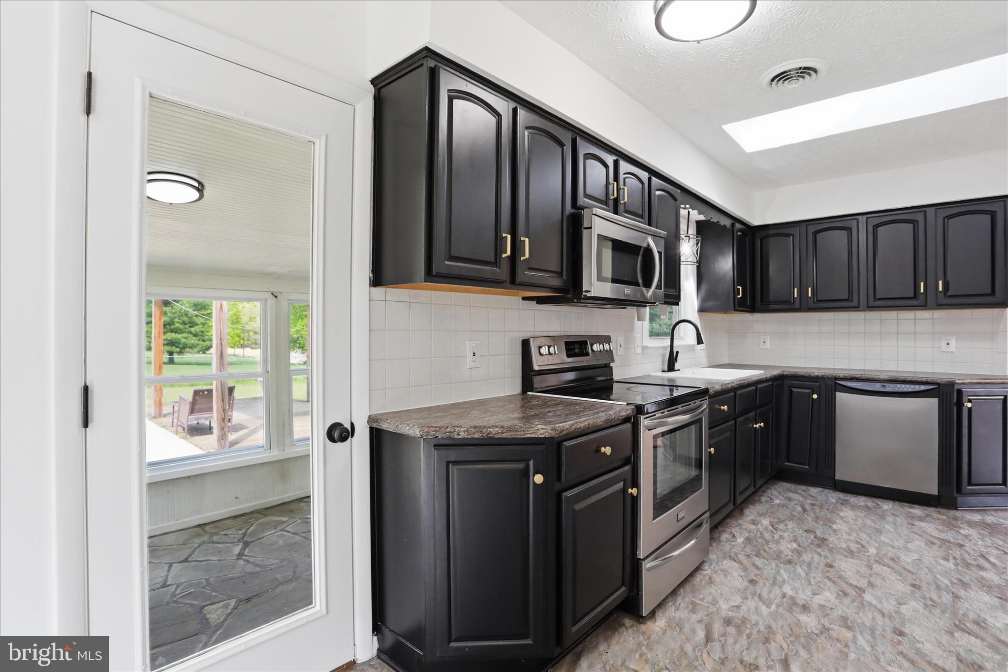 55 Highland Ridge Road Berkeley Springs, WV 25411 - Photo 20 of 44 a kitchen with stainless steel appliances granite countertop a stove sink microwave and cabinets