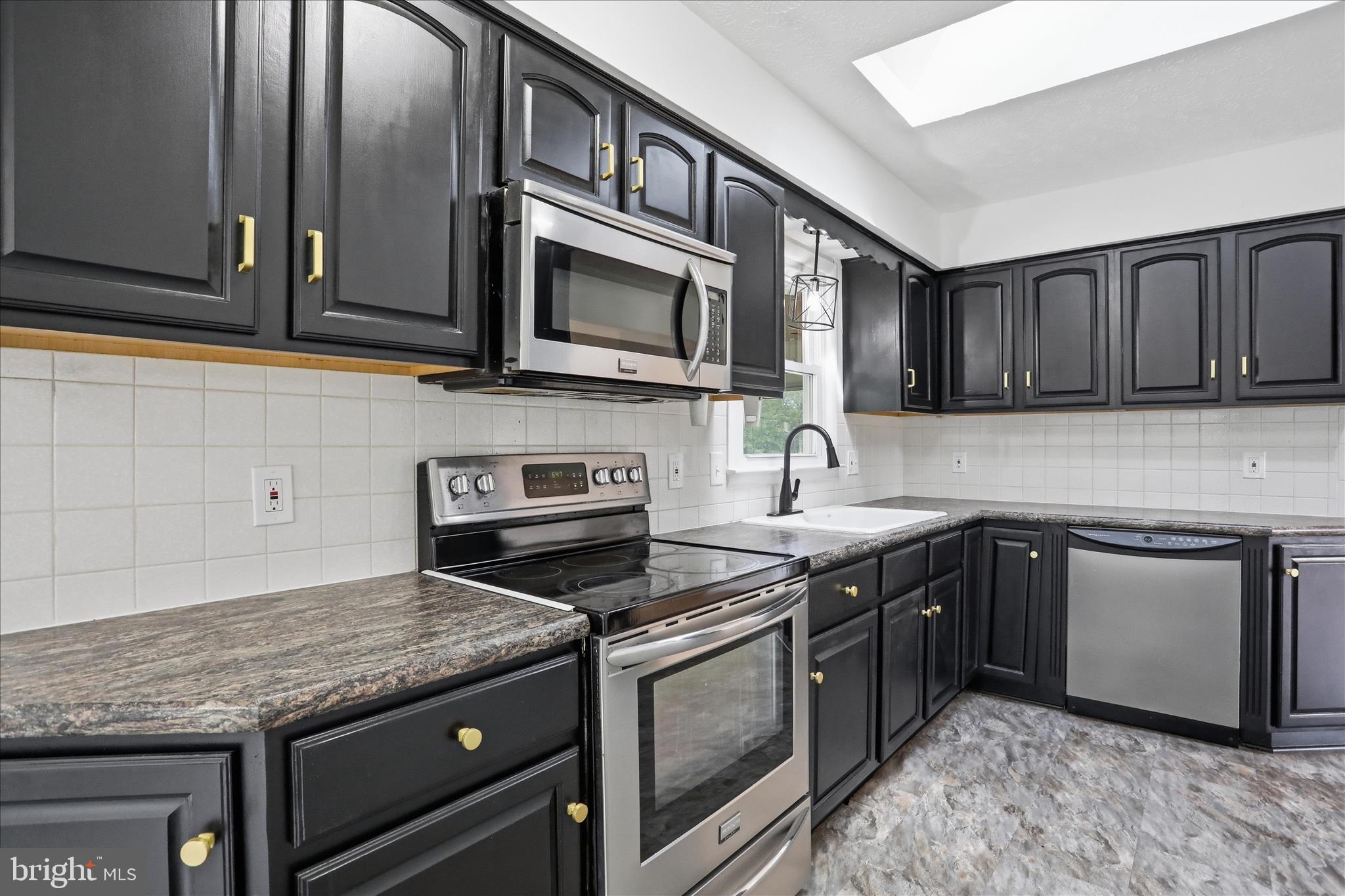 55 Highland Ridge Road Berkeley Springs, WV 25411 - Photo 23 of 44 a kitchen with stainless steel appliances granite countertop a stove microwave and sink
