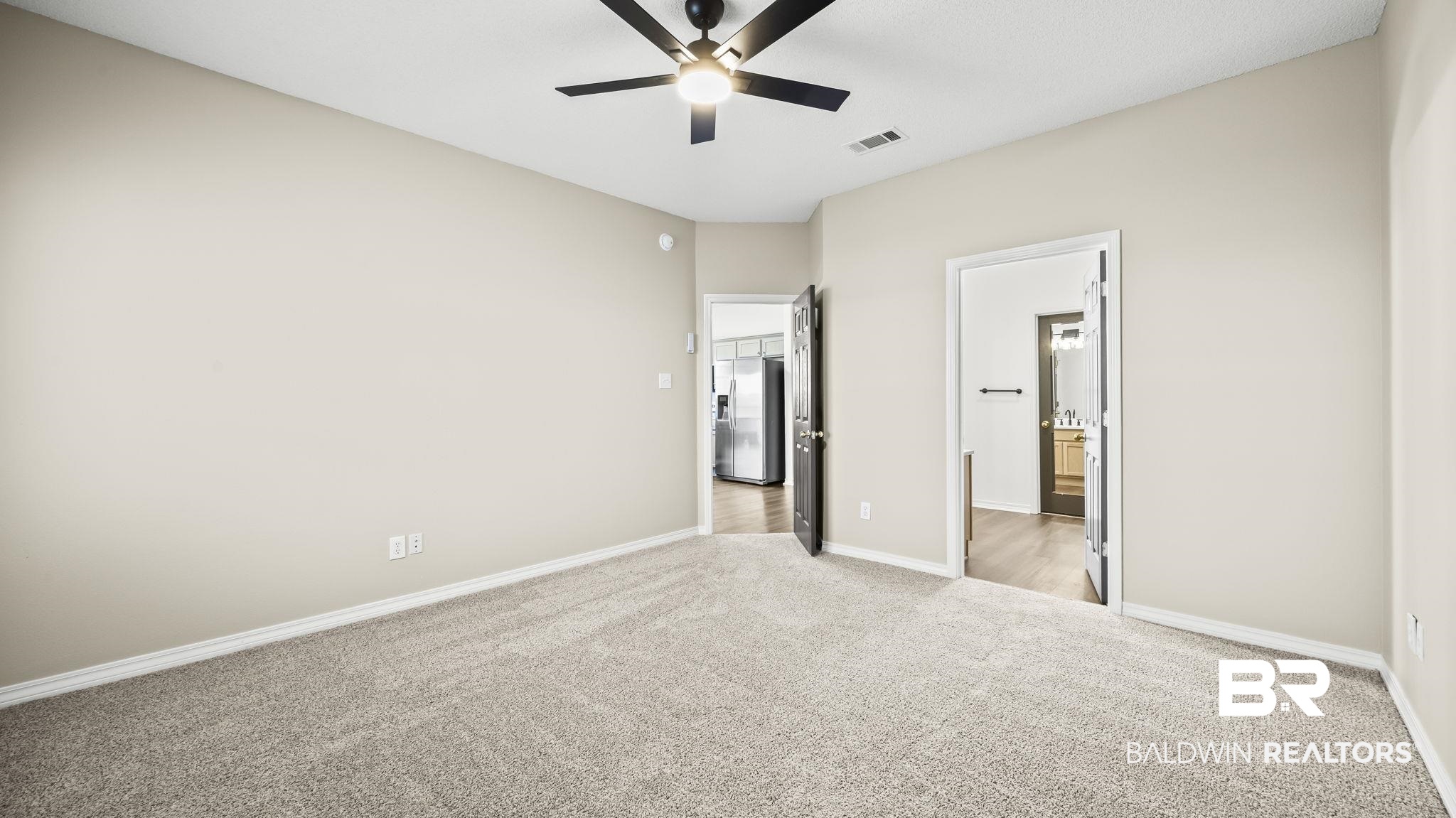 2651 South Juniper Street, Unit 705 Foley, AL 36535 - Photo 12 of 37 Spacious room featuring neutral carpeting, light-toned walls, and a ceiling fan with integrated lighting