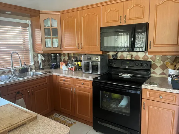 a kitchen with granite countertop a stove top oven cabinetry a sink and dishwasher