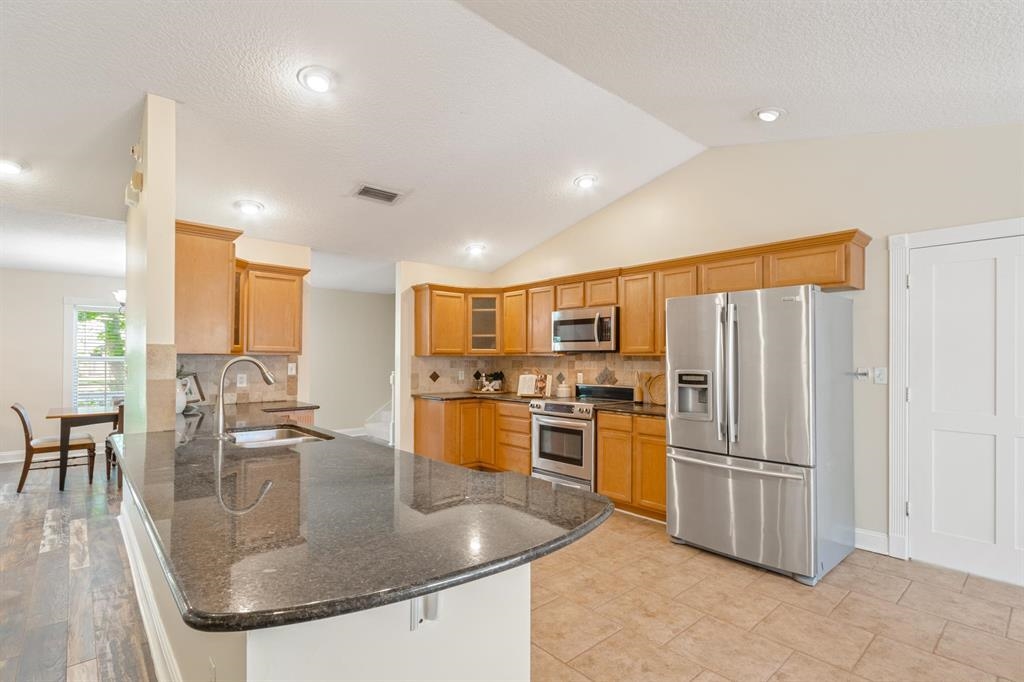 205 Shirley's Way St. Augustine, FL 32086 - Photo 13 of 56 a kitchen with stainless steel appliances granite countertop a sink a stove and a refrigerator