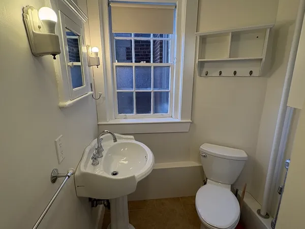a bathroom with a toilet sink and mirror