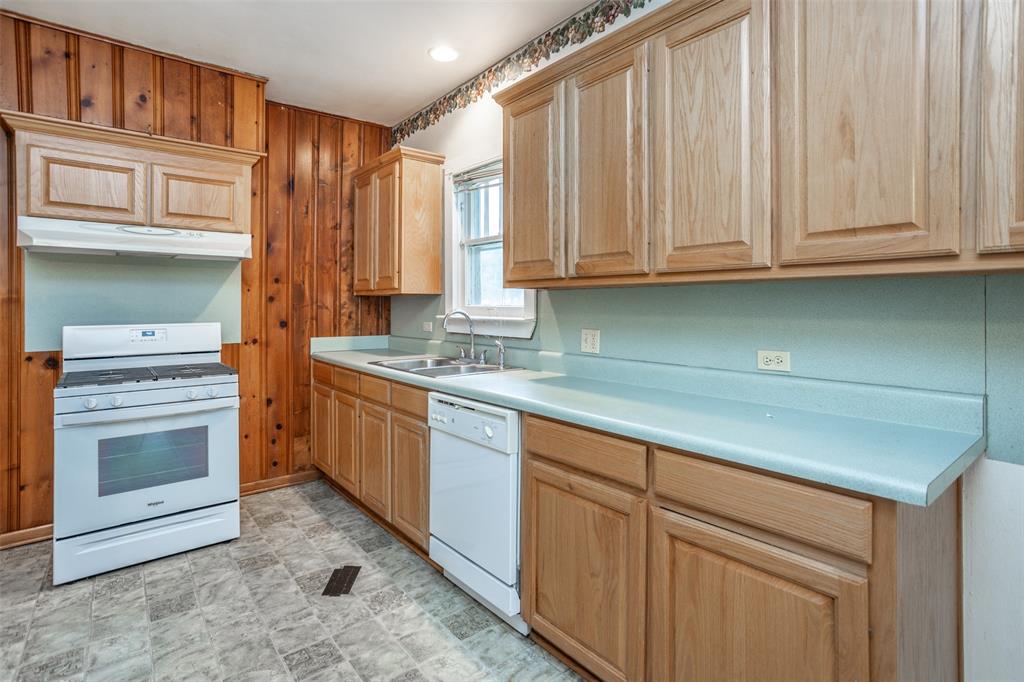 206 Ritchey Street Gainesville, TX 76240 - Photo 11 of 36 a kitchen with granite countertop white cabinets stainless steel appliances and sink