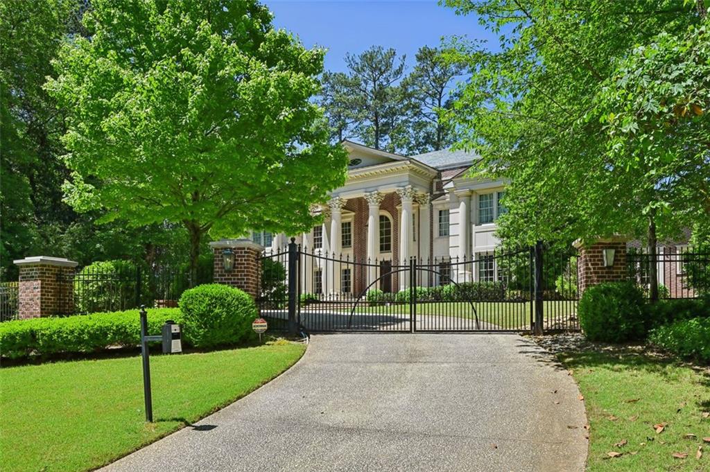 a front view of a house with a yard and green space