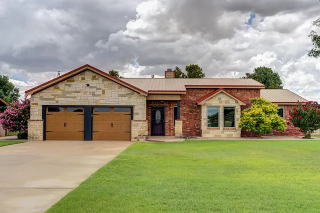 a front view of a house with a garden and yard
