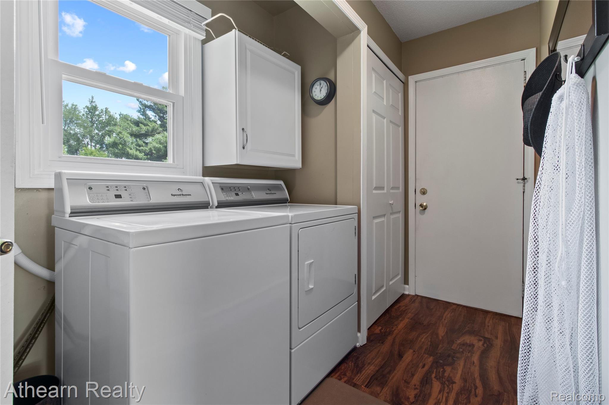 12427 Foley Road Fenton, MI 48430 - Photo 38 of 47 Laundry area featuring wood-finish flooring and a white window with exterior tree views
