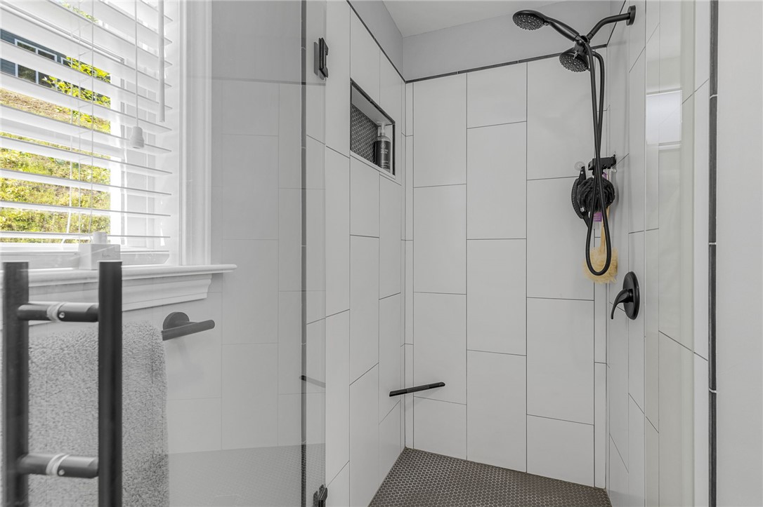 1230 Melton Road, Unit 82 West Union, SC 29696 - Photo 25 of 50 This modern bathroom features a tiled shower with sleek black fixtures and natural light.