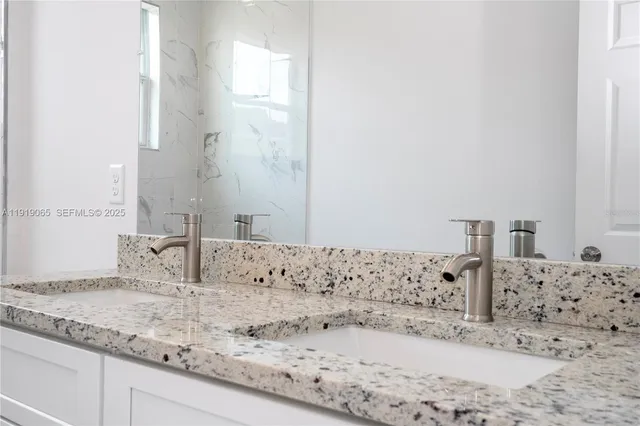 a bathroom with a granite countertop sink and a mirror