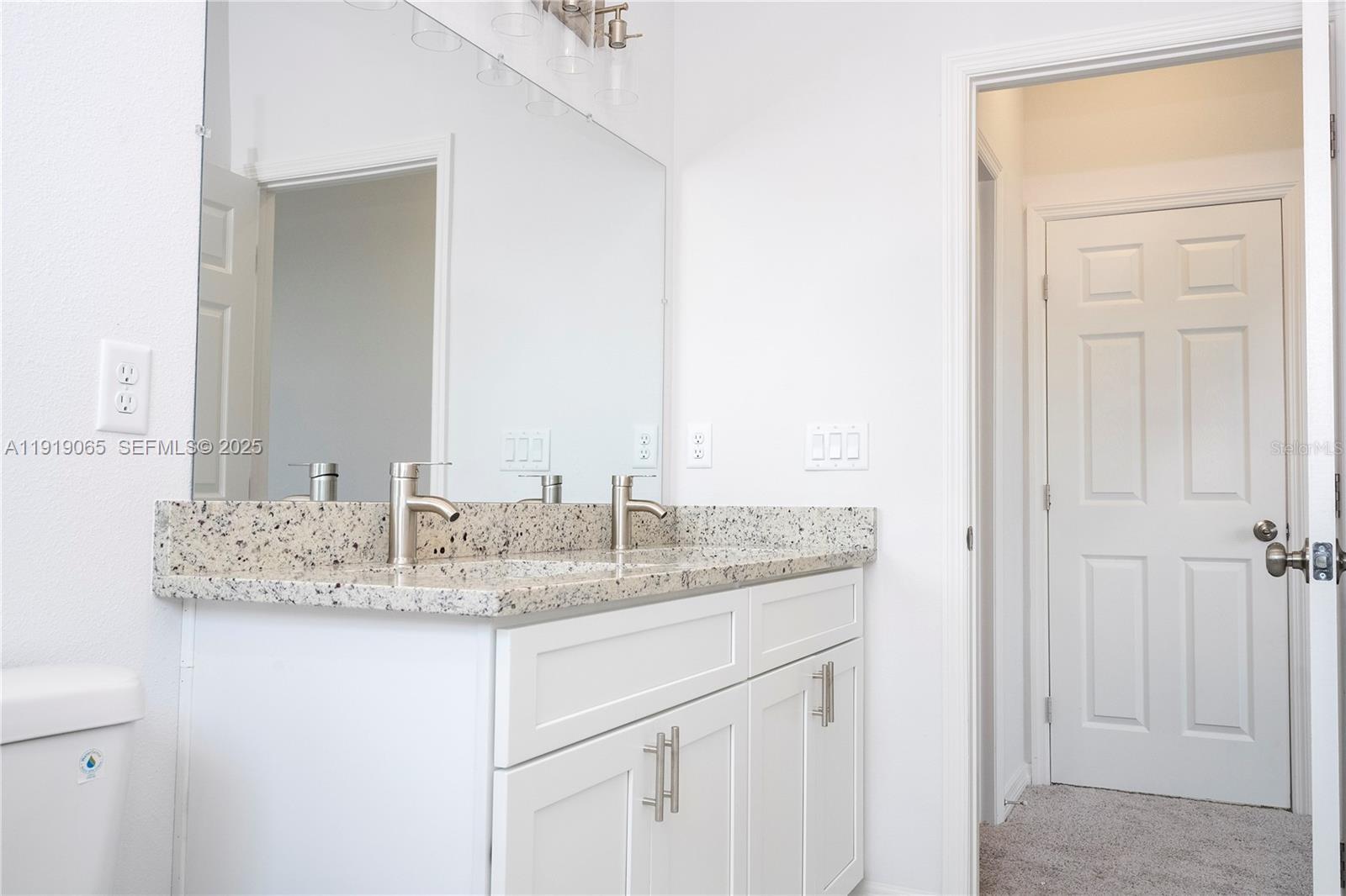 873 Colville Drive, Unit 873 Kissimmee, FL 34759 - Photo 27 of 47 a bathroom with a granite countertop sink and a mirror