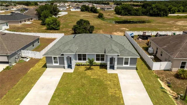 an aerial view of a house with swimming pool and outdoor seating
