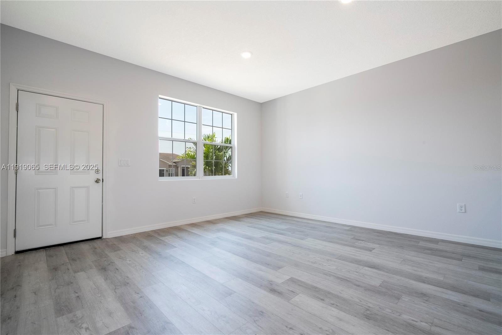873 Colville Drive, Unit 873 Kissimmee, FL 34759 - Photo 8 of 47 an empty room with wooden floor and windows