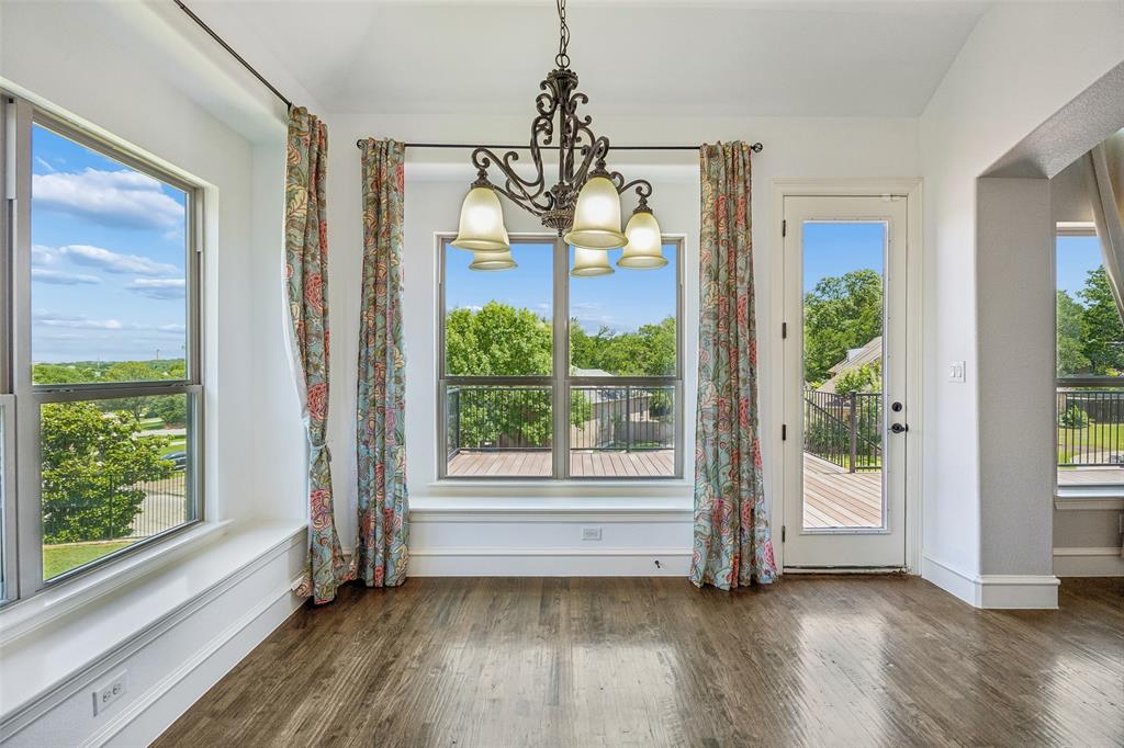 134 Santa Rosa Way Irving, TX 75062 - Photo 8 of 26 Light-filled dining space with panoramic windows and a charming chandelier, creating an inviting setting for everyday meals.