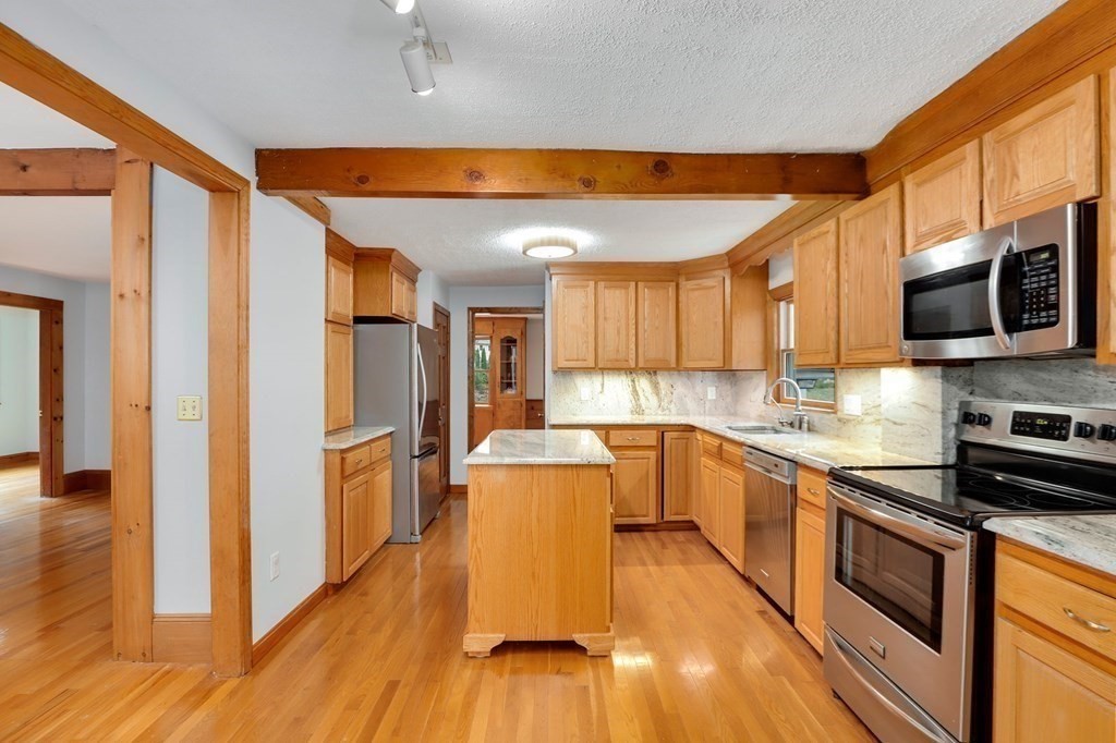 79 Dalton Road Chelmsford, MA 01824 - Photo 3 of 40 a kitchen with stainless steel appliances a stove top oven a sink a refrigerator white cabinets and wooden floor