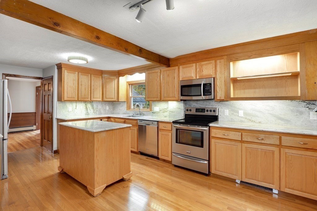 79 Dalton Road Chelmsford, MA 01824 - Photo 5 of 40 a kitchen with granite countertop a stove top oven a sink a counter space and cabinets