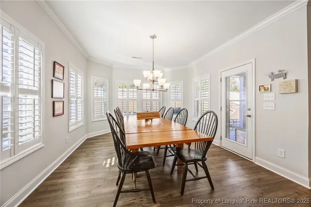 a dining room with furniture a chandelier and wooden floor