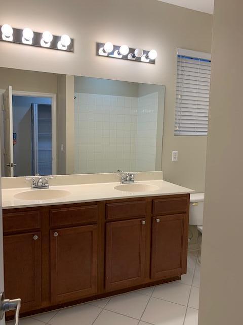 6729 Bulrush Court Greenacres, FL 33413 - Photo 15 of 35 a bathroom with a sink and a mirror
