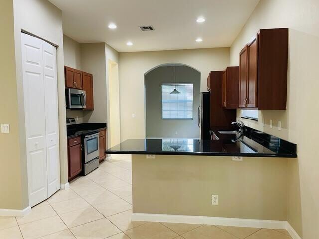 6729 Bulrush Court Greenacres, FL 33413 - Photo 18 of 35 a kitchen with stainless steel appliances a refrigerator and a stove