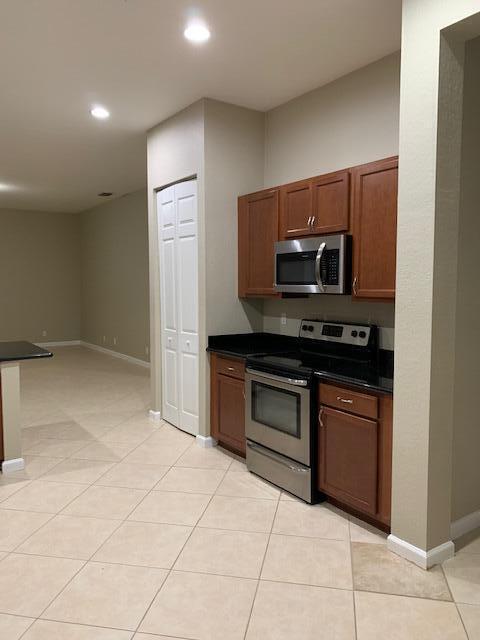 6729 Bulrush Court Greenacres, FL 33413 - Photo 22 of 35 a kitchen with stainless steel appliances granite countertop a refrigerator and a stove top oven