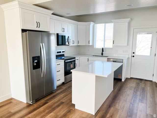 526 West 2000 South Vernal, UT 84078 - Photo 14 of 19 Kitchen with stainless steel appliances, white cabinetry, a center island, and dark wood-type flooring