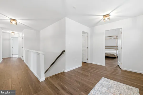 a view of a hallway view with wooden floor and a ceiling fan