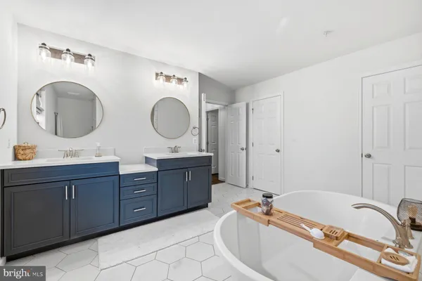 a bathroom with a tub sink and mirror