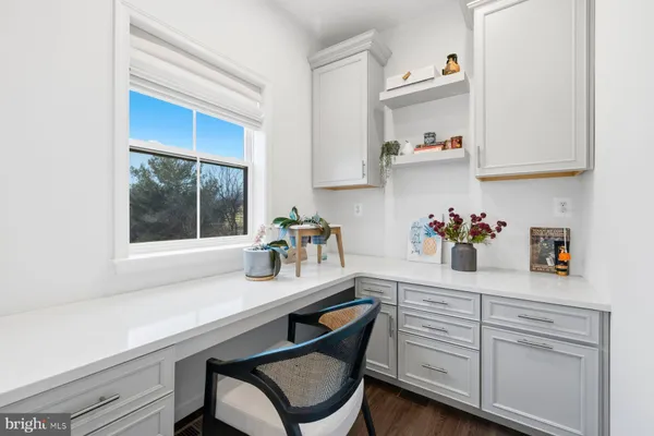 a kitchen with white cabinets and table