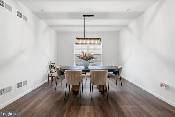 a dining room with furniture wooden floor and a chandelier