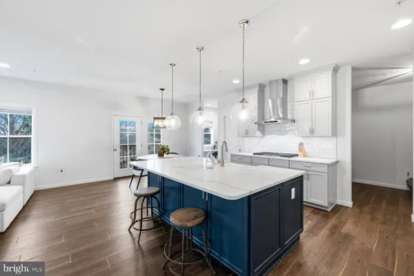 a kitchen with a sink a stove a refrigerator and white cabinets with wooden floor