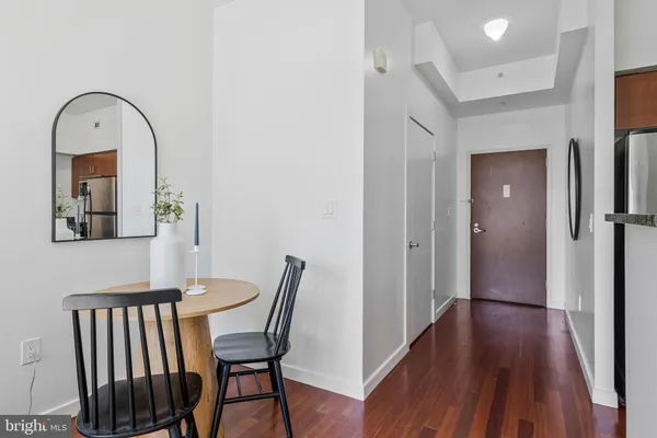 a view of a hallway view of a livingroom with wooden floor and furniture