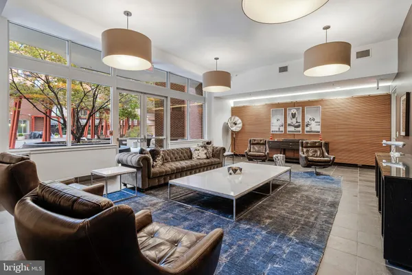 a living room with furniture a flat screen tv and kitchen view