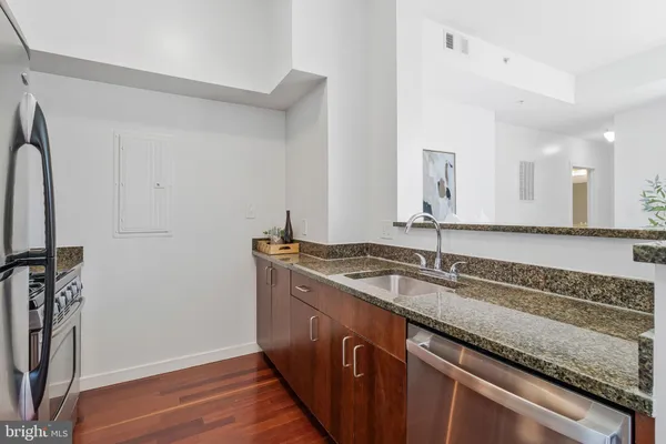 a view of a kitchen counter space a sink wooden floor and a window