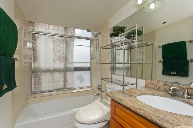 a bathroom with a granite countertop sink toilet mirror and shower