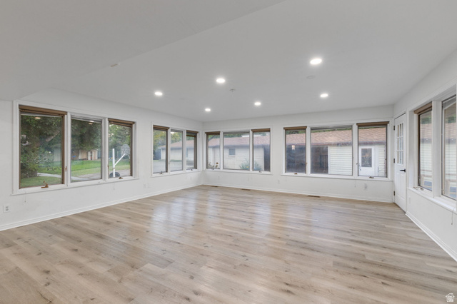 875 Cedar Hollow Road Lehi, UT 84043 - Photo 64 of 76 Spacious room featuring light wood-finish flooring, recessed lighting, multiple windows with natural wood trim, and a paneled door with a privacy glass insert