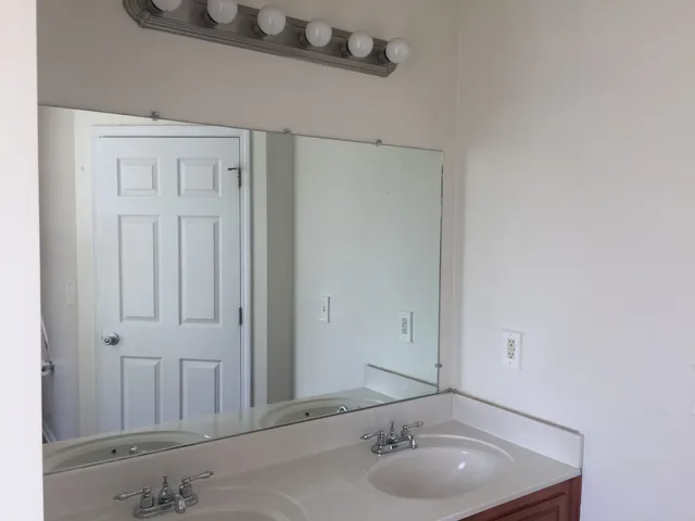a bathroom with a granite countertop sink and a mirror