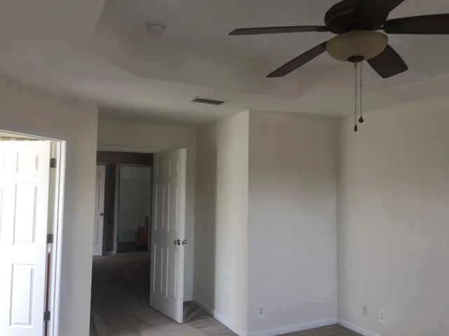 a view of hallway with chandelier fan