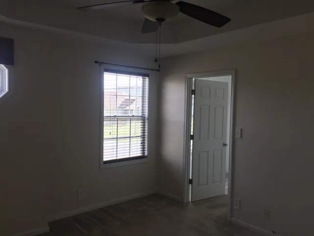 a view of a livingroom with a chandelier fan and a window