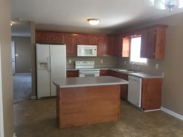 a kitchen with kitchen island granite countertop cabinets and refrigerator